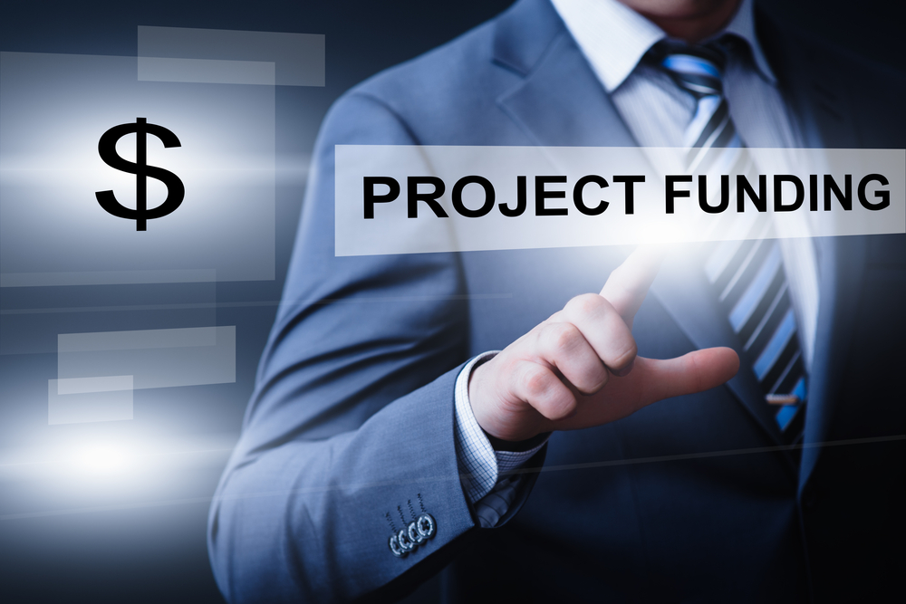 Man pressing a button that says project funding