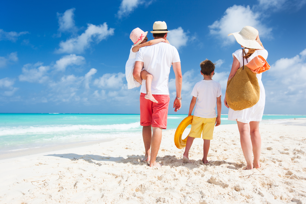 Family on white sand beach.