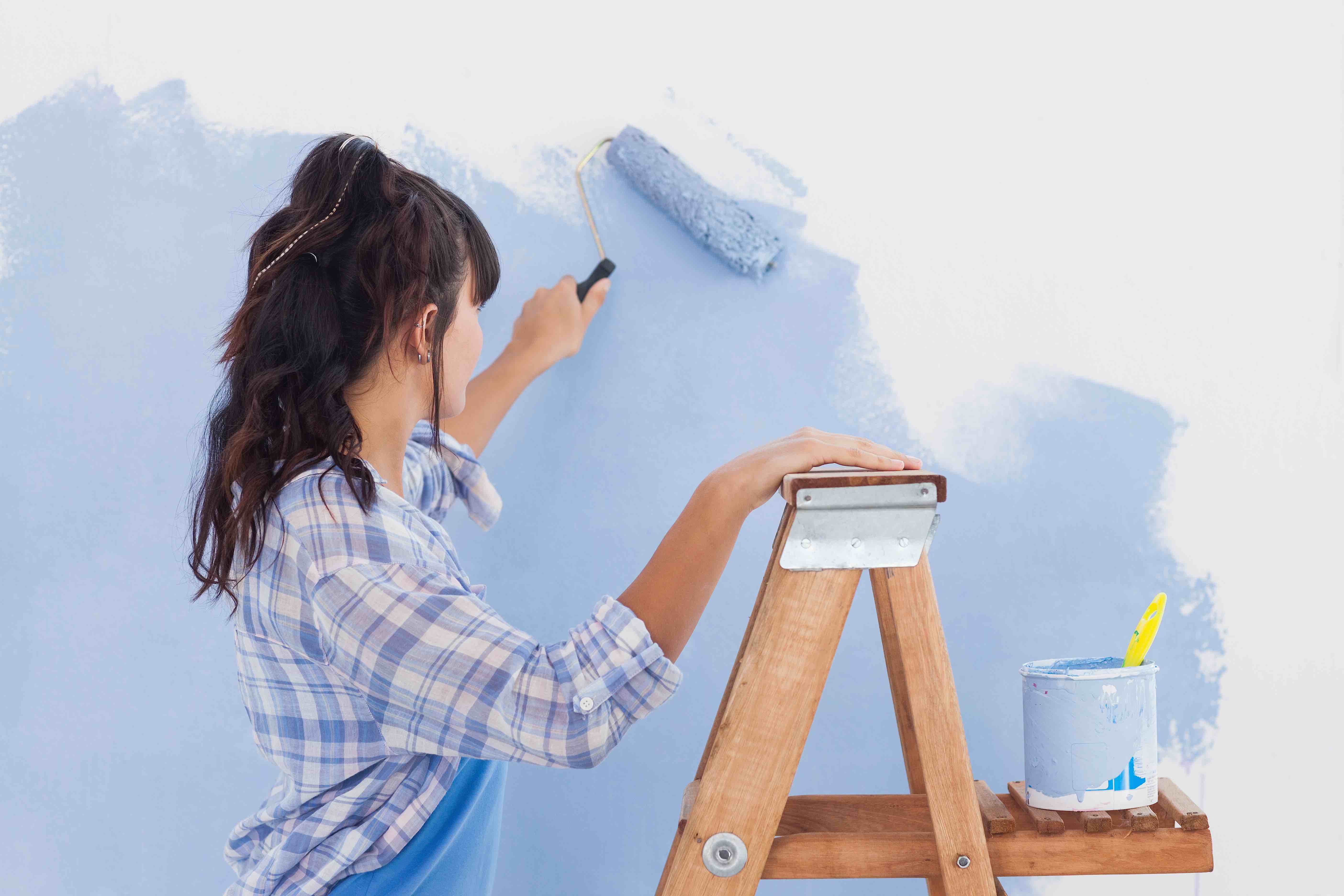 Woman painting walls blue